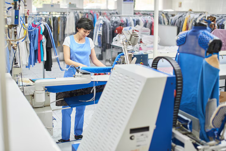 A Professional Laundry Worker Operating a Commercial Steam Press
